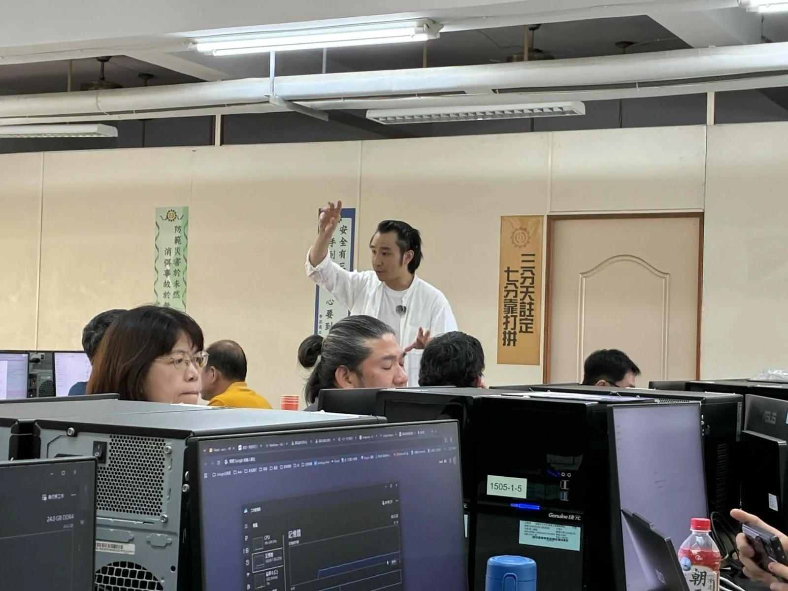 Dawson Wang 在中正高工電腦教室中穿梭於老師座位之間講解 AI 實作流程